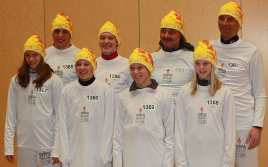 Triathleten tragen olympische Flamme